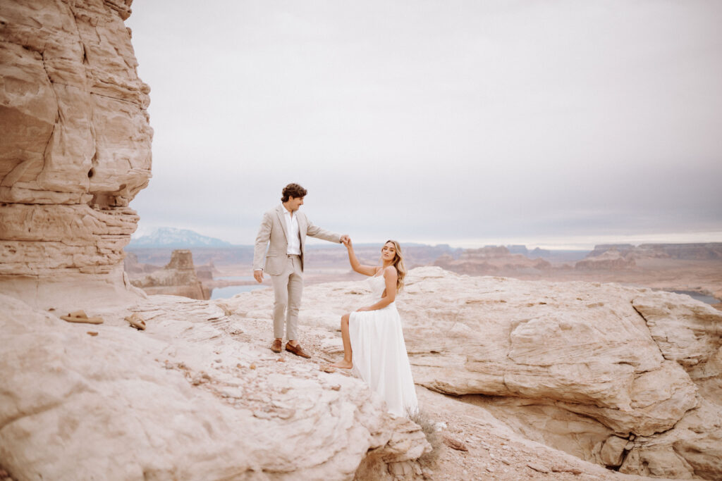 after eloping the groom helped the bride walk on the cliffs