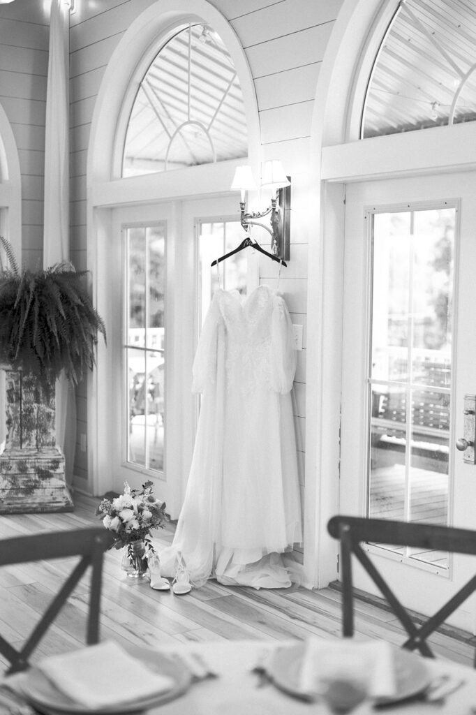 Black and white detail shot of the wedding dress hanging in the reception hall.